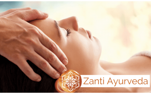 A woman receives an ayurvedic head massage from a masseuse.